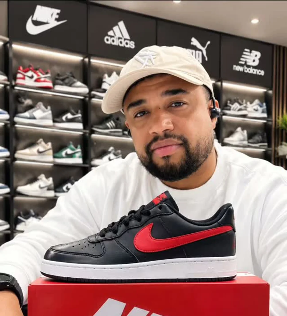 O Tio atrás do balcão, com o Nike preto e vermelho sobre a caixa